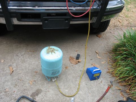 1995 Ford C-350 (Centurion Conversions) - AC service equipment connected to the front of a vehicle, with an R134a tank on the ground.
