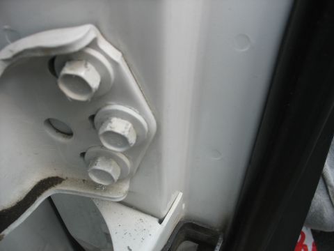 1995 Ford C-350 (Centurion Conversions) - Close-up view of the door hinge bolts, likely for adjustment purposes.