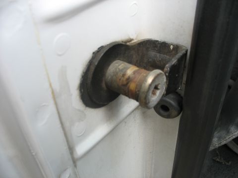 1995 Ford C-350 (Centurion Conversions) - Door hinge pin showing rust and wear on a white vehicle.