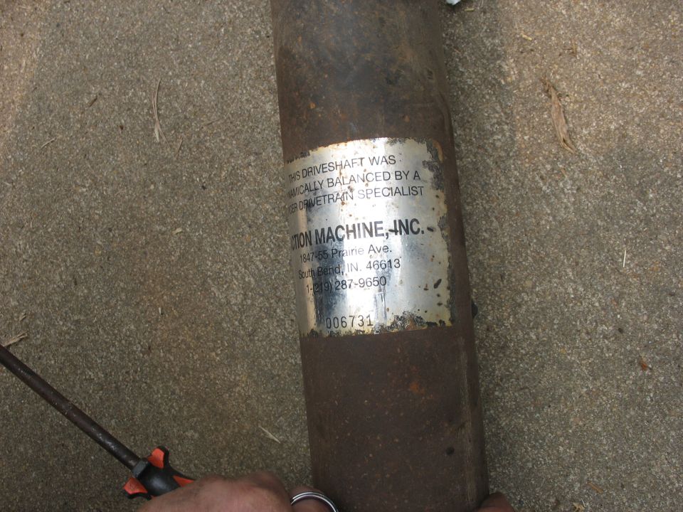 Driveshaft with a metal label from Traction Machine, Inc. showing address and phone number