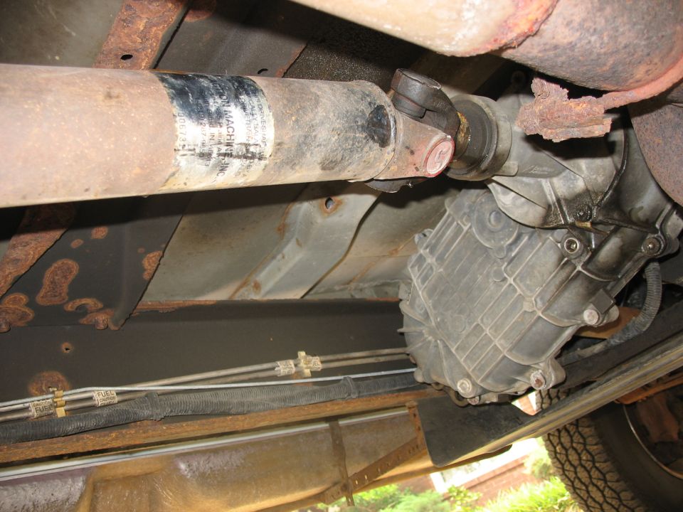Driveshaft and transfer case assembly with visible rust and wear