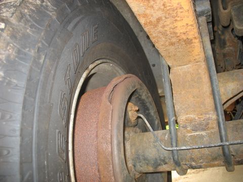 1995 Ford C-350 (Centurion Conversions) - The rear axle, leaf spring, and drum brake assembly show significant rust.