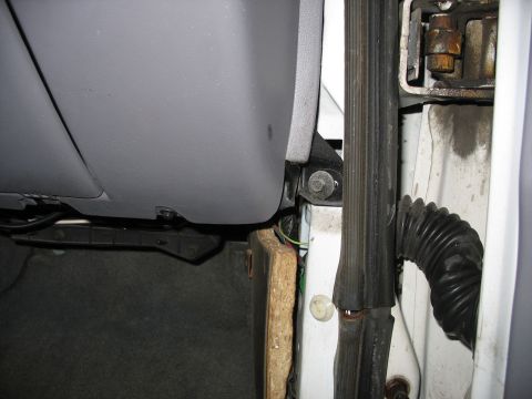 1995 Ford C-350 (Centurion Conversions) - Close-up view of the interior door jamb and dash panel, revealing exposed wiring and insulation material.