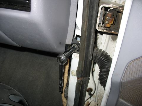 1995 Ford C-350 (Centurion Conversions) - A ratchet is used to remove a bolt from the interior dashboard panel.