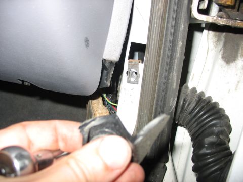 1995 Ford C-350 (Centurion Conversions) - Close-up view of interior car components, including gray paneling, wiring, and a hand holding a detached clip.