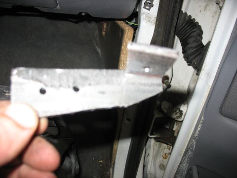 1995 Ford C-350 (Centurion Conversions) - A metal bracket is held up for inspection inside a vehicle's interior.