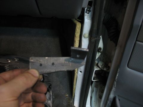 1995 Ford C-350 (Centurion Conversions) - Close-up of a metal bracket being held in front of the interior door frame of a vehicle.