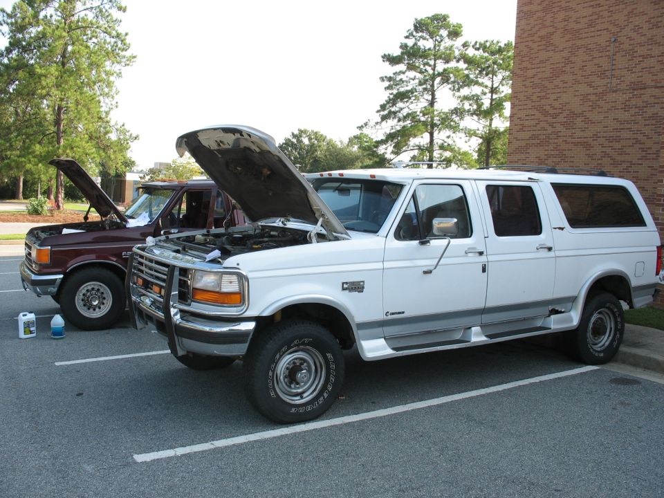 1995 Ford C-350 (Centurion Conversions) and a maroon Ford van, both with hoods open, parked in a lot