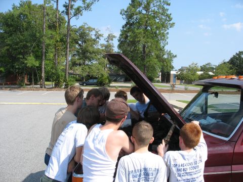 1995 Ford C-350 (Centurion Conversions) - A group of boys inspect the engine of a truck, with some wearing Boy Scout-themed t-shirts.