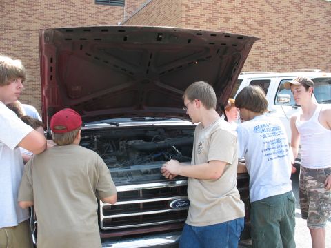 1995 Ford C-350 (Centurion Conversions) - Young men inspect the engine of a 1995 Ford C-350 (Centurion Conversions) truck.