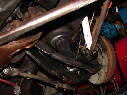 1973 Ford Ranchero - Underside view of a vehicle in a cluttered garage showing an automatic-transmission torque converter with visible ring-gear teeth hanging i…