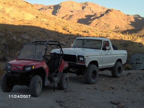 1979 Ford Bronco - White 1978 Ford Bronco and a red ATV are parked in a desert scene.