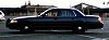 2001 Ford Crown Victoria - A dark-colored 2001 Ford Crown Victoria police car is seen from the side in a parking lot.