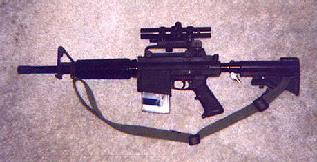 2001 Ford Crown Victoria - An assault rifle with a scope and sling is displayed against a textured background.