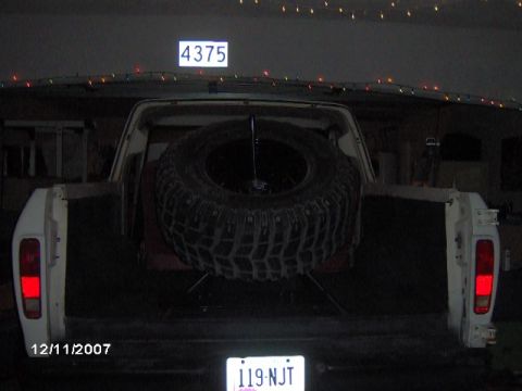 1979 Ford Bronco - Rear view of a white 1979 Ford Bronco with a spare tire in the cargo area and a house number 4375 visible above.