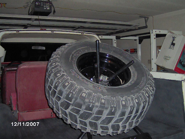 Spare tire mounted inside a vehicle with red seats visible