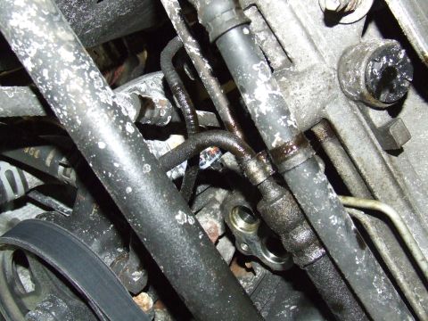 2003 Ford Crown Victoria - Close-up view of engine oil cooler lines, showing some wear and residue.