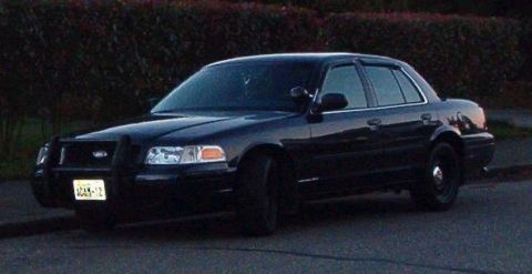 2001 Ford Crown Victoria - This black 2001 Ford Crown Victoria, equipped with a push bar, is seen parked curbside.