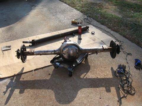 1968 Shelby GT500 - A disassembled rear axle assembly and driveshaft are laid out on cardboard, with tools scattered around.