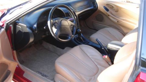 1996 Ford Probe - The interior features tan leather seats and a dashboard, with 'PROBE' visible on the driver's side floor mat.