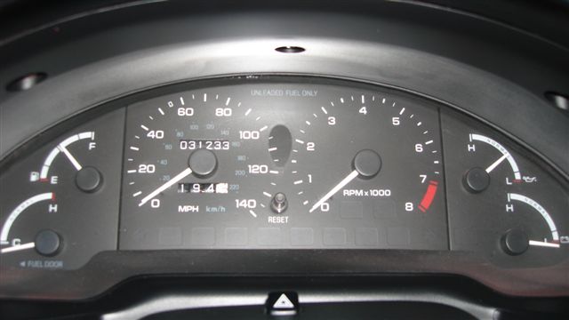 Car dashboard with speedometer, tachometer, fuel gauge, and oil pressure gauge. Odometer shows 031233 miles