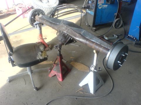 1985 Ford Bronco - Rear axle assembly supported by jack stands in a workshop setting.