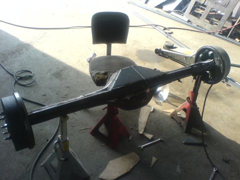1985 Ford Bronco - A vehicle's rear axle assembly is supported by jack stands in a workshop setting.
