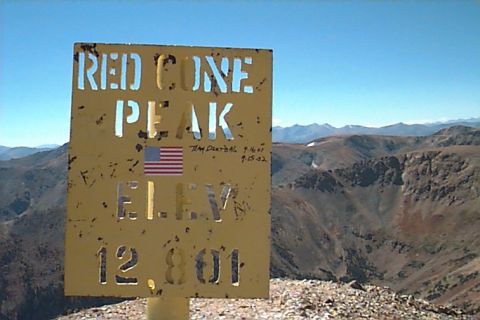 1994 Ford Bronco - A sign marks Red Cone Peak at an elevation of 12,801 feet, set against a backdrop of mountains under a clear blue sky.