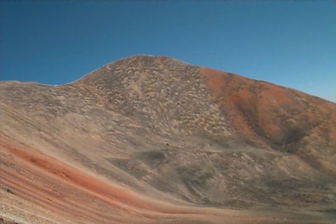 1994 Ford Bronco - A vast mountain landscape displays a mix of brown and red soil tones beneath a clear blue sky, with a Supermotors watermark at the bottom r…