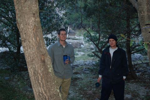1997 Ford F-250 - Two men stand in a natural outdoor setting with trees and rocks visible.