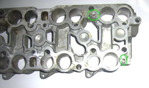 1997 Ford Taurus - Close-up of an aluminum intake manifold part with visible bolt holes and markings.