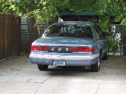 Light blue Mercury Grand Marquis sedan viewed from the rear in a driveway