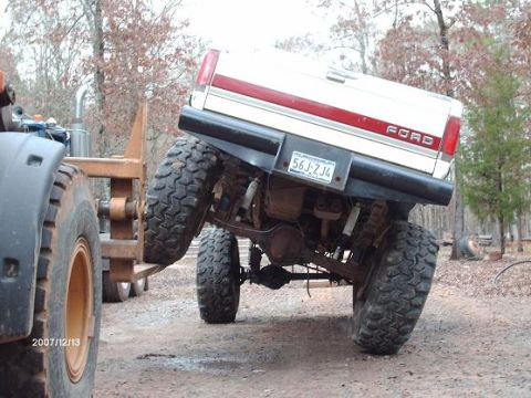 1990 Ford F-150 - Rear view of a 1990 Ford F-150 pickup truck modified with large off-road tires.