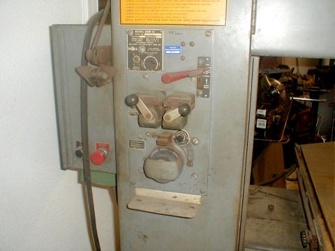 1996 Ford Bronco - A gray industrial drill press with various controls and a red emergency stop button is visible.