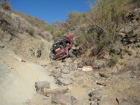 1987 Suzuki Samurai - A modified 1987 Suzuki Samurai is stuck on a steep, rocky incline in a desert landscape.