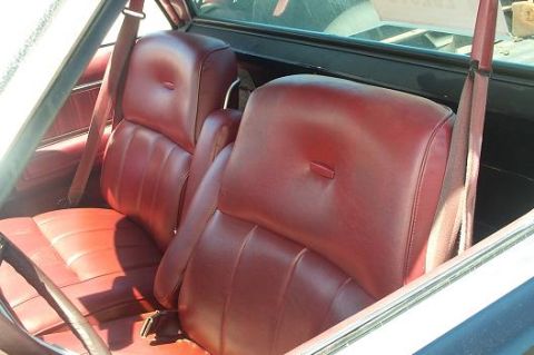 1979 Ford Ranchero - Interior view of red leather bucket seats and seatbelts within a vehicle.