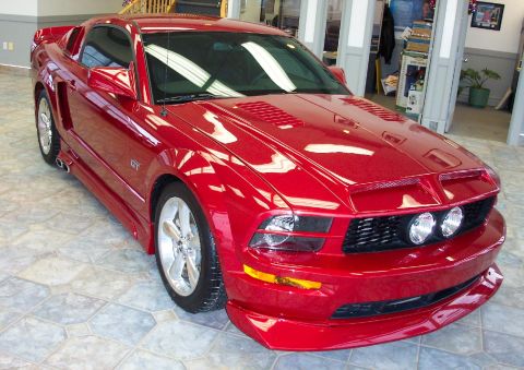 2008 Ford Mustang - Red Ford Mustang GT parked indoors on a tiled floor.