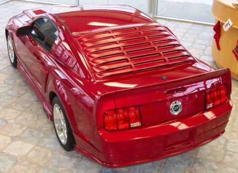 2008 Ford Mustang - Rear view of a red Ford Mustang GT, distinctive horizontal louvers on the rear window and a GT badge.