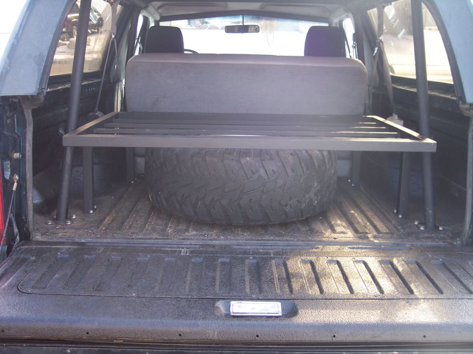 1995 Ford Bronco interior showing spare tire and custom metal storage rack above it