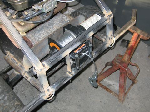 2001 Ford F-150 - This custom-built vehicle features a winch and engine components, with a red jack nearby.