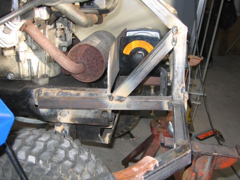 2001 Ford F-150 - Close-up of a lawnmower's engine and fabricated frame, showing a rusty exhaust and a control box.