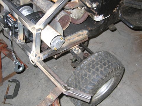 2001 Ford F-150 - Close-up view of a winch and custom metal frame attached to a lawnmower component.