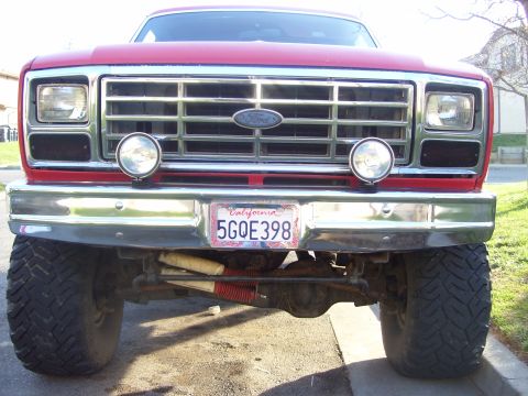 1986 Ford Bronco - Front view of a red 1986 Ford Bronco, its distinctive grille and chrome bumper.