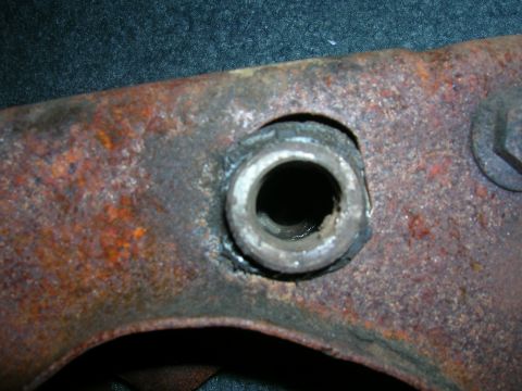 1979 Ford Bronco - Detail of a heavily rusted metal component, likely a vehicle part, showing a central hole and surrounding corrosion.