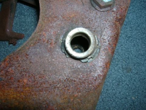 1979 Ford Bronco - Heavily rusted metal part with a hole and a nut visible.