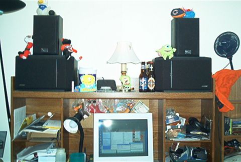 1985 Ford LTD Crown Victoria - A shelf displays stereo speakers, toys, beer bottles, and a lamp, with a computer monitor below.