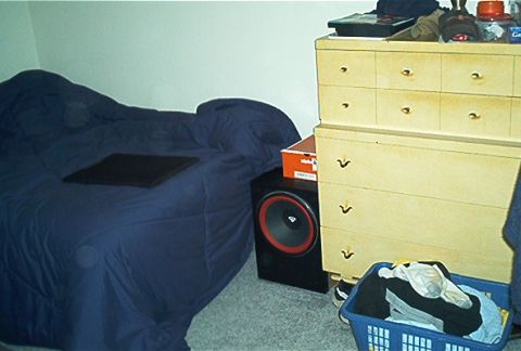 1985 Ford LTD Crown Victoria - A stereo speaker is visible next to a dresser and a bed in a room.
