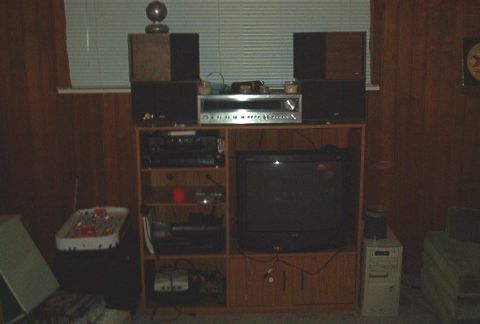 1985 Ford LTD Crown Victoria - A home stereo system is set up with speakers, a television, and a computer tower, suggesting a media or entertainment area.