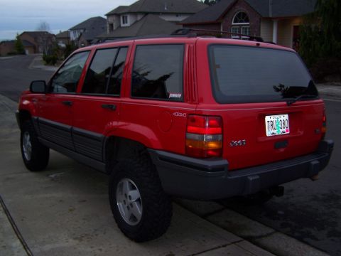 1994 Jeep Grand Cherokee - Rear view of a red 1994 Jeep Grand Cherokee parked curbside.