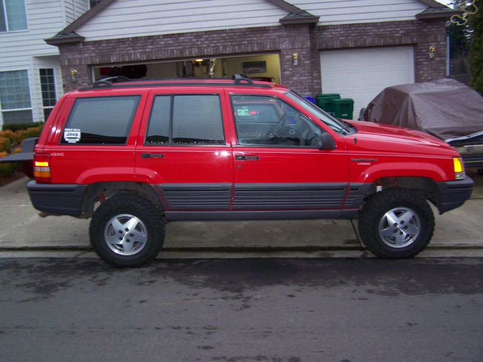 Red 1994 Jeep Grand Cherokee side view with aftermarket wheels